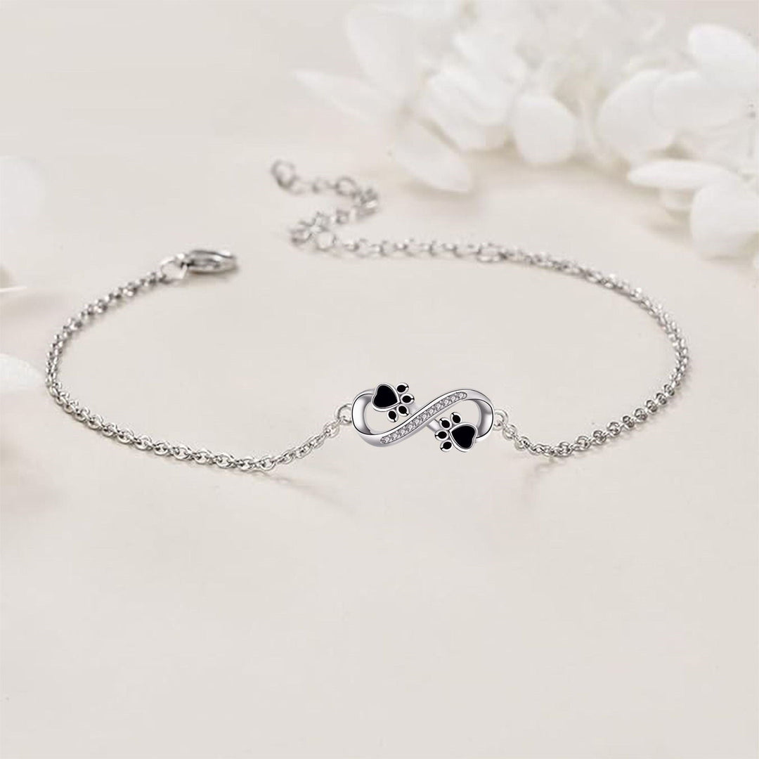 Bracelet avec symbole de l'infini, charms avec empreinte de patte et zircons