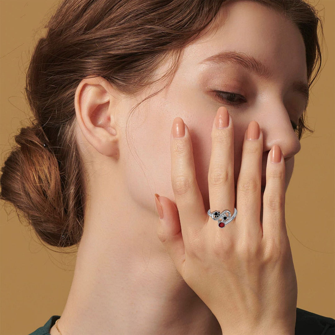 Anneau réglable avec pattes de chat noires et pierre précieuse rouge